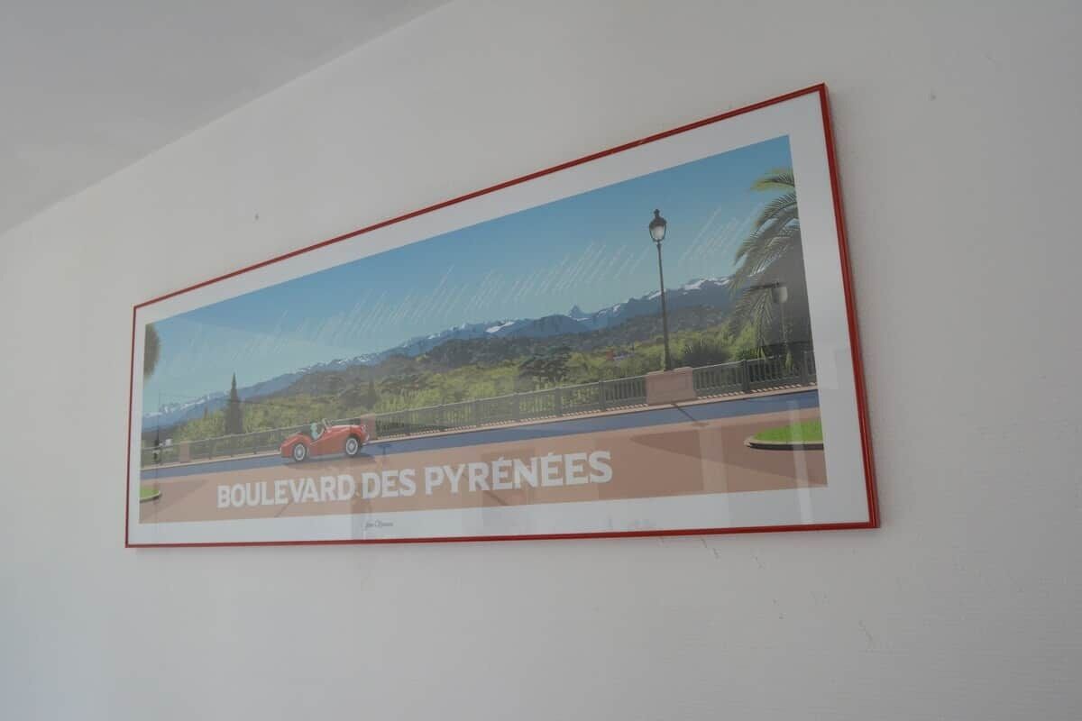A framed picture of a road with a red car and text 'BOULEVARD DES PYRÉNÉES'.