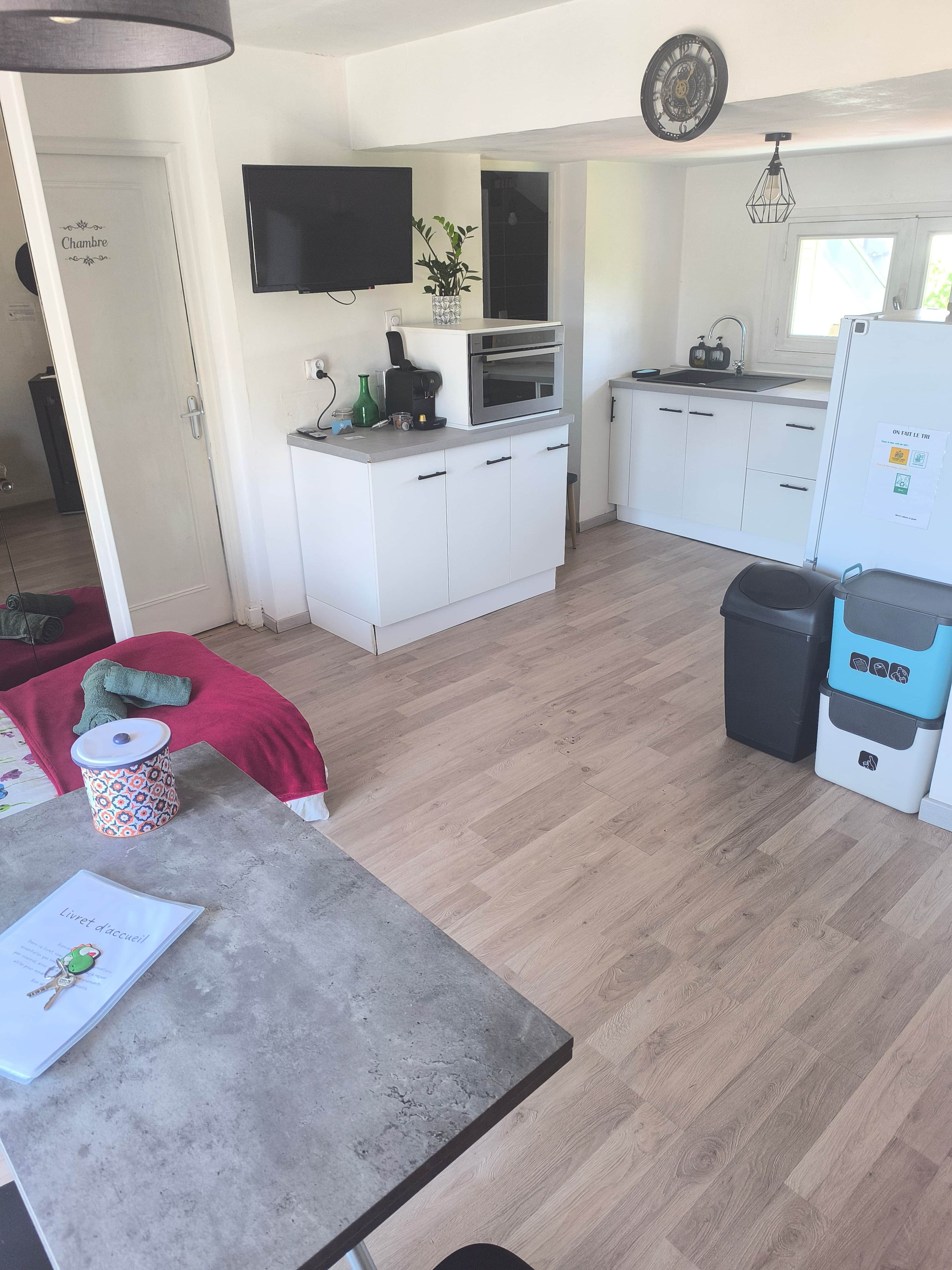 A compact kitchen with white cabinets, a built-in oven, a microwave, and a sink.