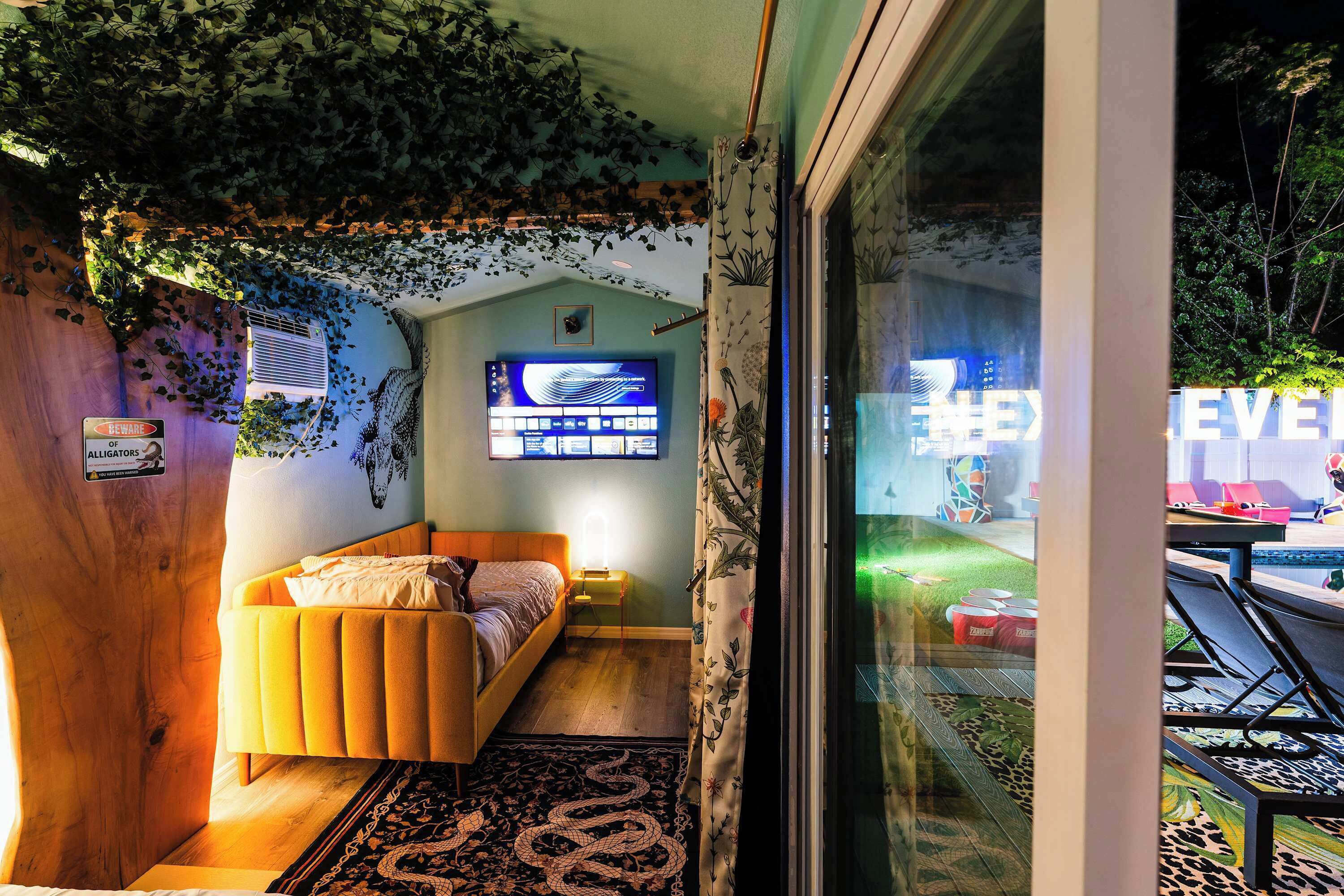 Un dormitorio con cama, televisor y vistas al exterior.