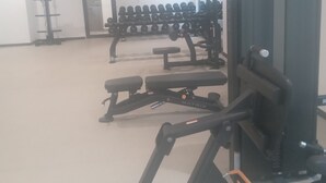 A gym with various exercise equipment, including dumbbells, benches, and a treadmill. - Executive Studio Room at Bantree Apartments,Accra Airport City (Accra)