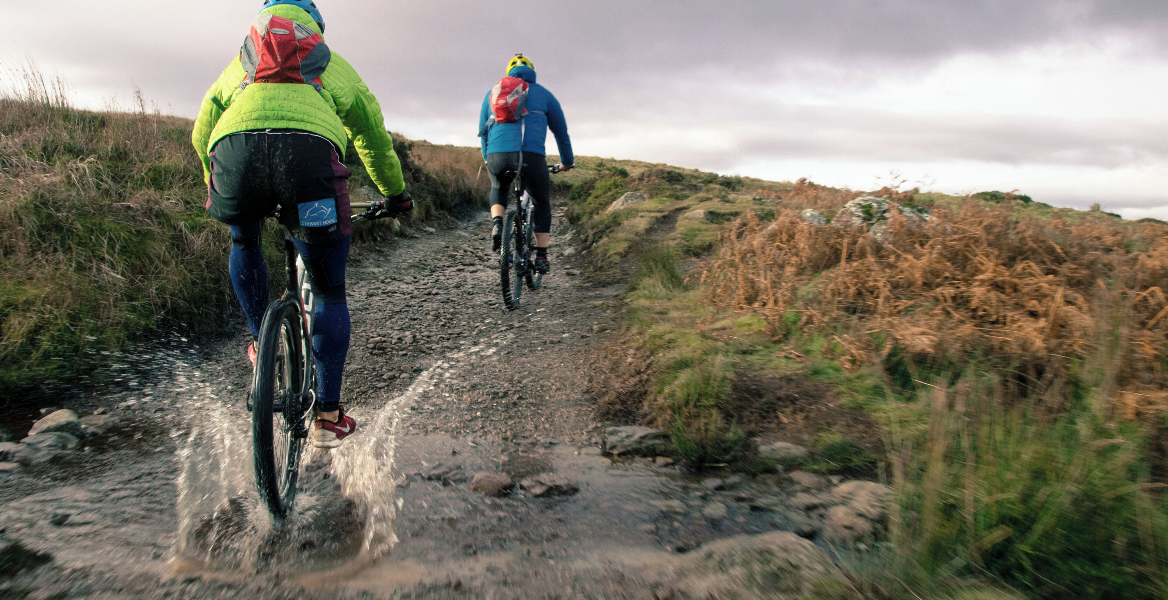 Dos ciclistas en un sendero embarrado.