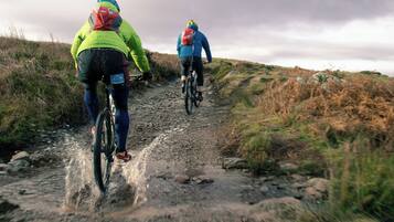 Dos ciclistas en un sendero embarrado.
