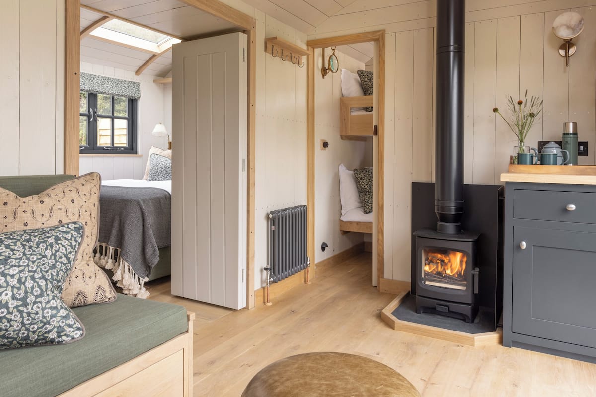 Una habitación acogedora con cama, sofá, chimenea y radiador.