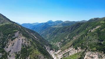 A mountainous landscape with a valley and distant peaks.