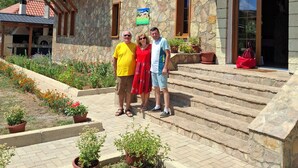A two-story building with a stone facade, a balcony with metal railings, and a staircase leading to the entrance. - Agroturizem Dr Bizhga (Picar)