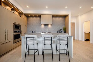 Fridge, microwave, oven, stovetop - Modern 2-bedroom condo with king beds in Kelowna across from Gyro Beach. Features a stunning 1,700 sq ft rooftop deck with lake views plus pool, hot tub, gym, and sauna. (kelowna)