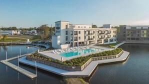 Un hotel moderno con piscina, muelle y vistas al agua.