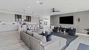 Ein modernes Wohnzimmer mit einer Couch, einem Couchtisch und einem an der Wand montierten Fernseher.