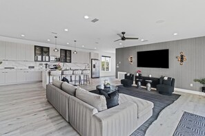 Una sala de estar moderna con un sofá, una mesa de centro y un televisor montado en la pared.
