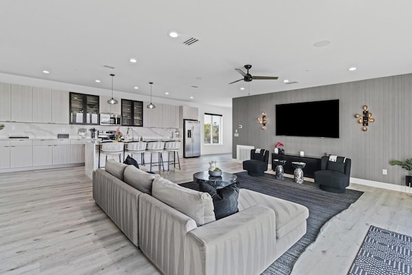 A modern living room with a sofa, coffee table, and a TV mounted on the wall.