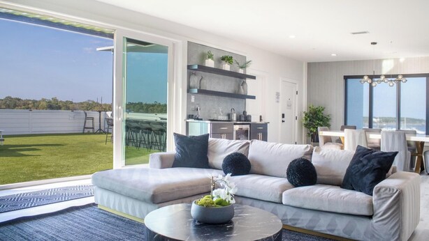 Ein modernes Wohnzimmer mit Sofa, Couchtisch und Blick ins Freie.
