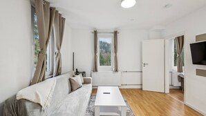 Una sala de estar moderna con un sofá, una mesa de centro y un televisor.