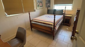 A bedroom with a bed, a desk, a chair, a window, and a door. - Relaxing Punta Gorda Getaway 3BR, Kayaks, Outdoor Oasis (Punta Gorda)