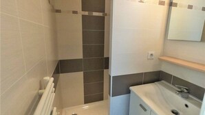 A bathroom with a shower, a sink, and a mirror. - Central house in quiet alley (La Tranche-sur-Mer)