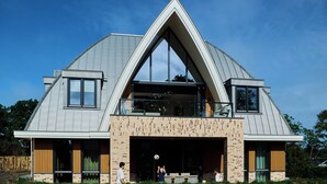A modern house with a triangular roof, large windows, and a covered garage. - Den Burg Holiday Home for 8 (Den Burg)