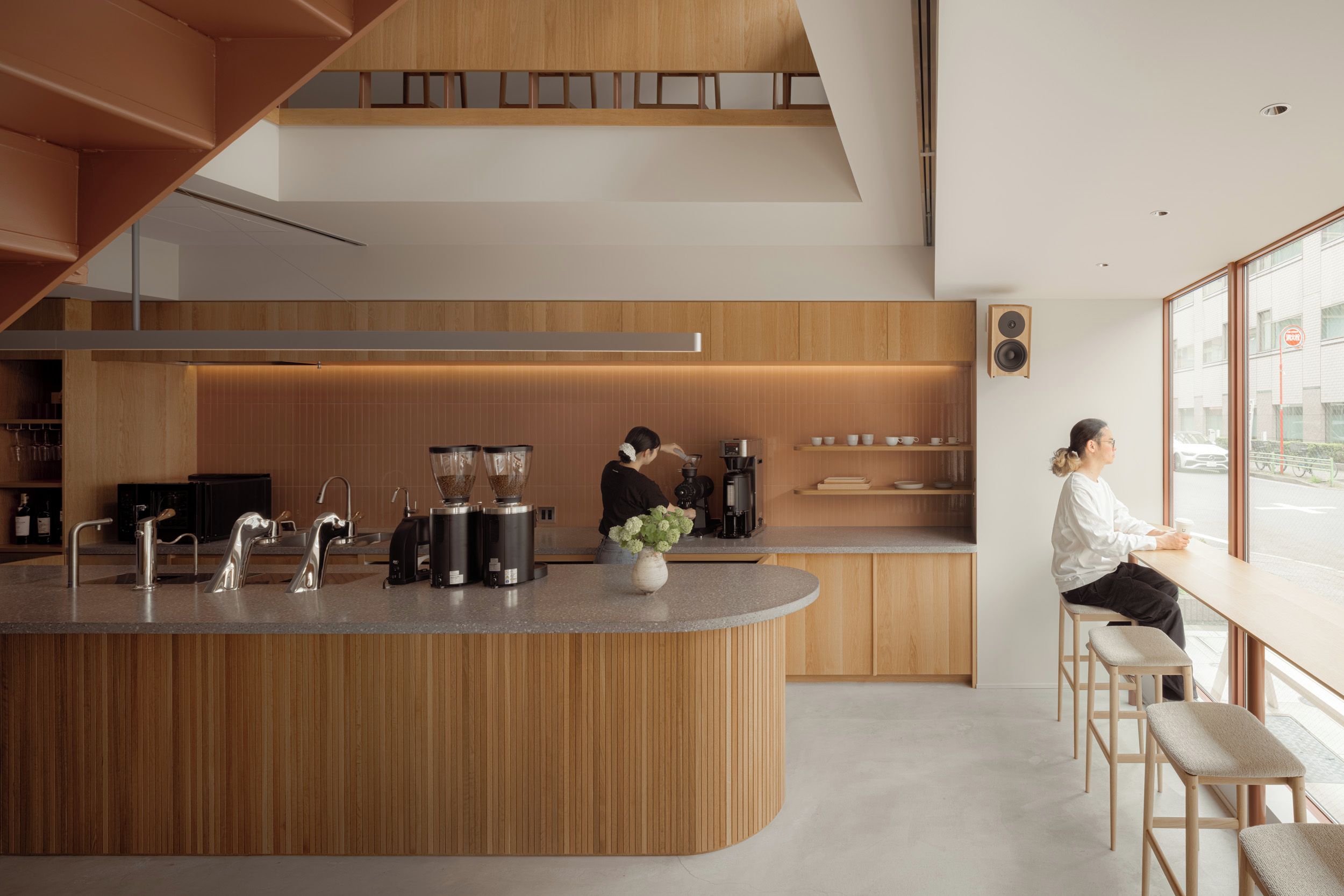 A modern kitchen with a central island, built-in appliances, and a seating area with a view.