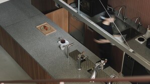 Eine moderne Küche mit einer Granitabdeckung, Edelstahlgeräten und einer Holzrückwand.