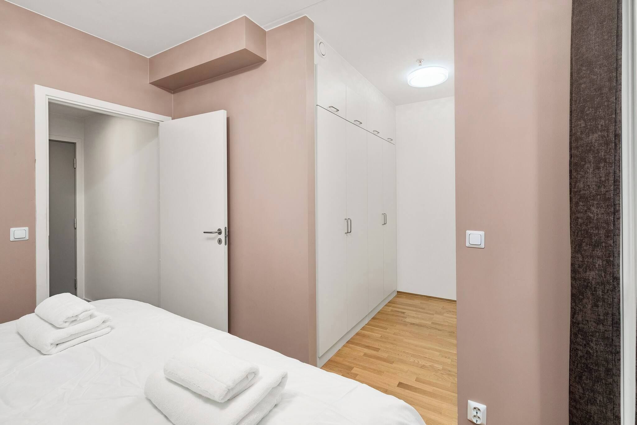 Un dormitorio con cama, armario y puerta a un pasillo.