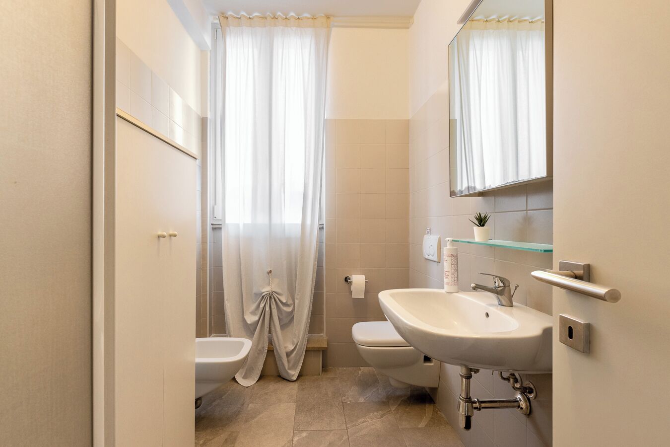 A bathroom with a sink, toilet, and shower curtain.
