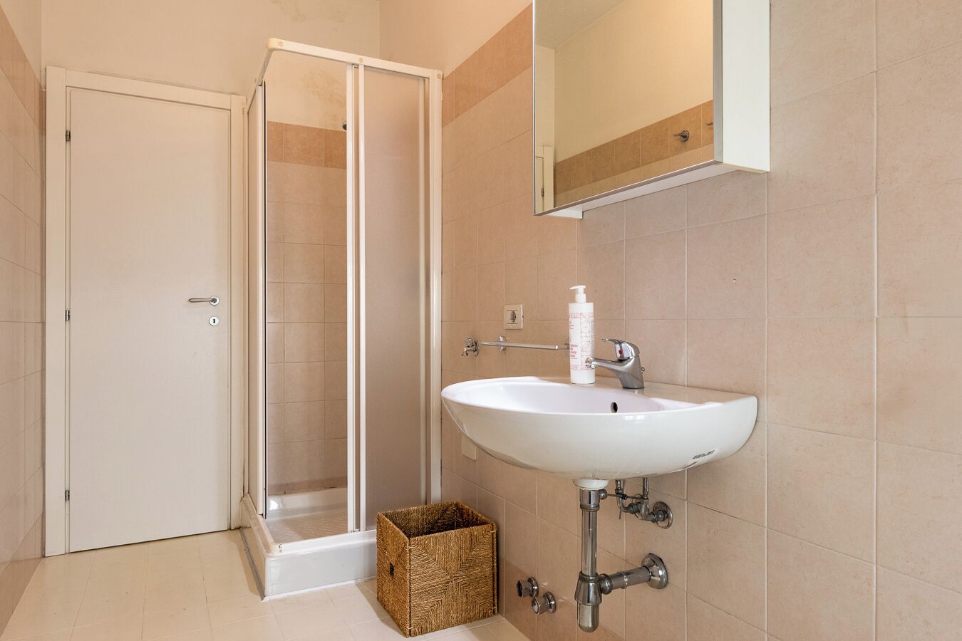 Un baño con ducha, lavabo y espejo.