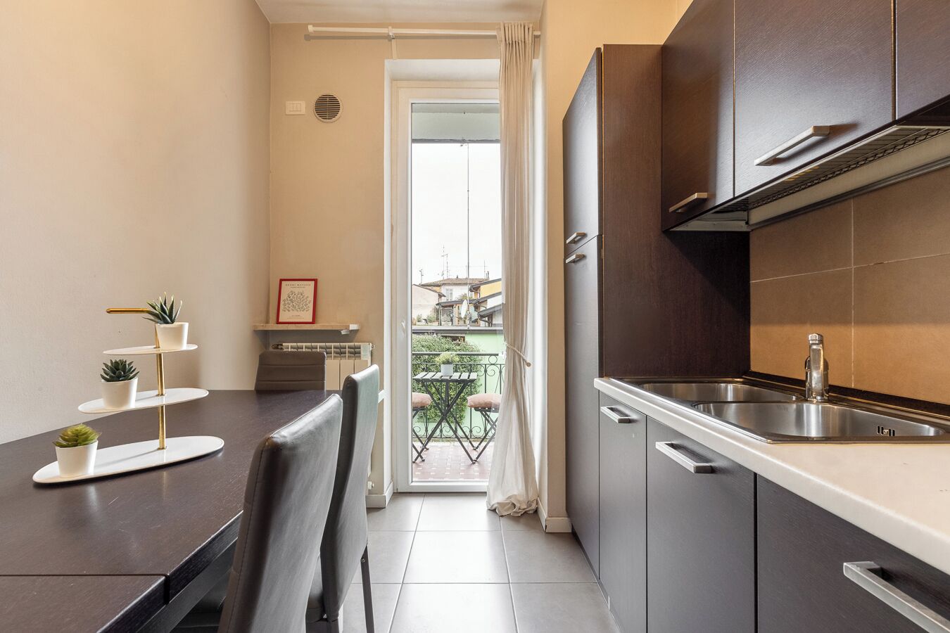 Una cocina compacta con comedor, vistas al exterior y un balcón pequeño.