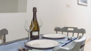 Et spisebord med en vinflaske, to glas og bestik.