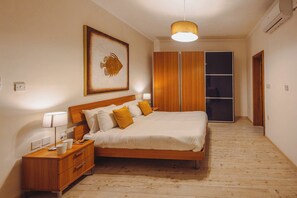 A bedroom with a wooden bed, bedside tables, a hanging lamp, a framed picture, and a wardrobe. - Spacious 3BR Retreat Overlooking Marina (Msida)