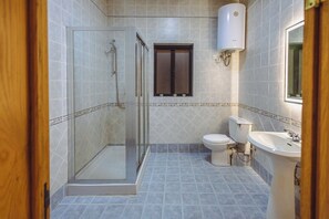A bathroom with a glass shower enclosure, a toilet, a sink, and a window. - Spacious 3BR Retreat Overlooking Marina (Msida)
