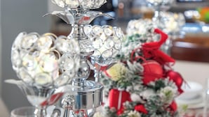 A table set with crystal glassware, a small Christmas tree, and a red tablecloth. - COZY APT 10 AIRPORT (Punta Cana)