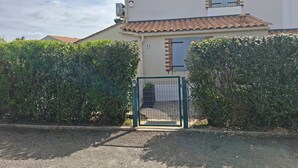 A two-story building with a tiled roof, a gated entrance, and a number '47' sign. - Holiday Home "La Maison De Marion" with Private Terrace, Wi-Fi, and Air Conditioning (La Tranche-sur-Mer)