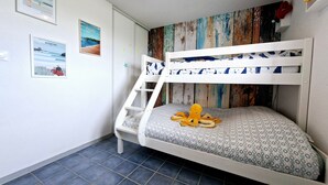 A bunk bed with a patterned mattress, a ladder, and a wall with a rustic wooden panel. - Holiday Home "La Maison De Marion" with Private Terrace, Wi-Fi, and Air Conditioning (La Tranche-sur-Mer)