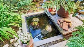 A garden with a pond, rocks, and various plants. - Maison KERVARREC (Saint-Gregoire)