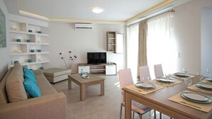 Un salon moderne comprenant un canapé, une table basse et un coin repas aménagé pour accueillir six personnes.