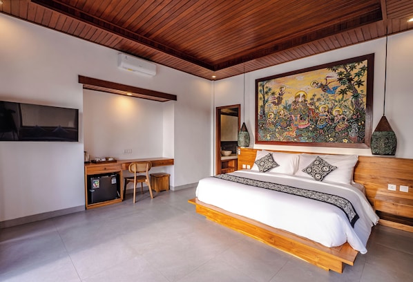 A bedroom with a bed, desk, chair, and a large painting on the wall. - Taru Sebatu Villa (Sebatu)