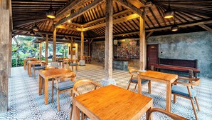 A rustic interior with wooden tables and chairs, a tiled floor, and a high ceiling with exposed beams. - Taru Sebatu Villa  (Sebatu)