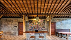 A rustic interior with a wooden ceiling, a mural, a bar area with stools, and a patterned floor. - Taru Sebatu Villa  (Sebatu)