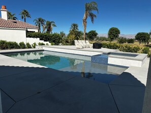 A swimming pool with a tiled edge, lounge chairs, and palm trees. - 3-bedroom estate in beautiful La Quinta with AC (La Quinta)