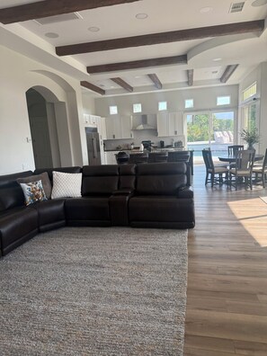 A spacious living area with a sectional sofa, a rug, and a view of the kitchen and dining area. - 3-bedroom estate in beautiful La Quinta with AC (La Quinta)