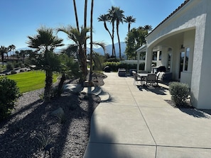 A patio area with outdoor furniture, palm trees, and a view of mountains. - 3-bedroom estate in beautiful La Quinta with AC (La Quinta)