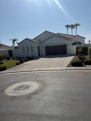 A residential house with a garage, a driveway, and a well-maintained lawn. - 3-bedroom estate in beautiful La Quinta with AC (La Quinta)