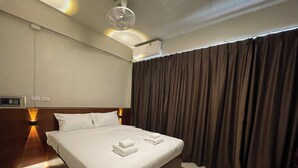 A hotel room with a large bed, a ceiling fan, an air conditioning unit, and a window with curtains. - ON'S Place (Pattaya)