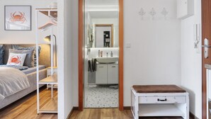 A bedroom with a bed, bedside table, and a mirror. - Apartment in the 'Krabbenkiste' Hotel with Sea View, Shared Garden, and Wi-Fi (Wunstorf)