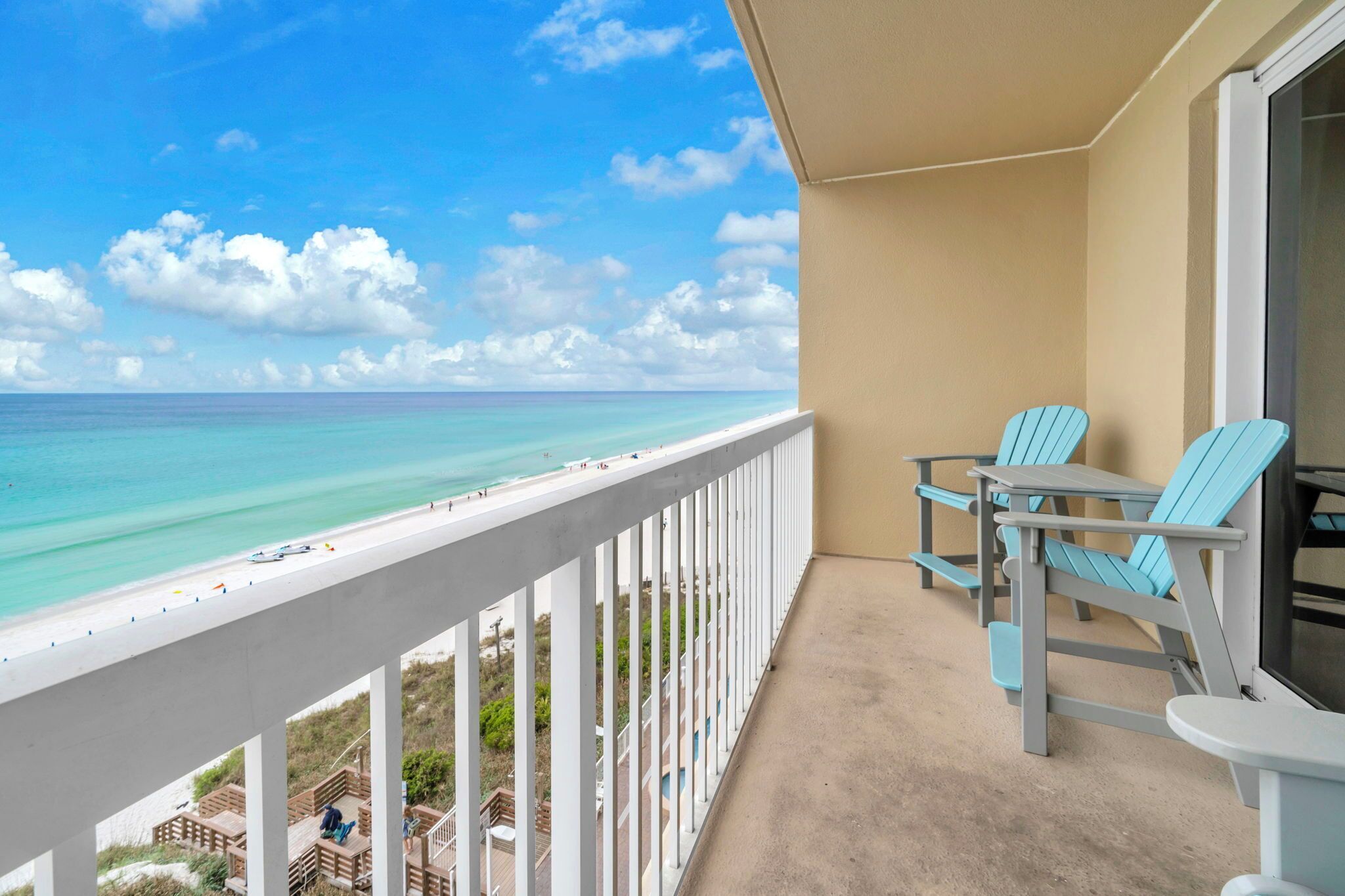 A balcony with a view of the beach and ocean.