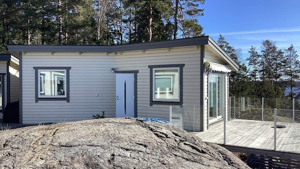 A small, single-story building with a grey exterior, two windows, and a door. - 5 Star Holiday Home in Varmdo (Värmdö)