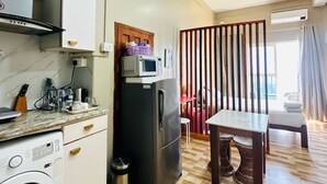Eine kompakte Küche mit Waschmaschine, Mikrowelle und Kühlschrank.
