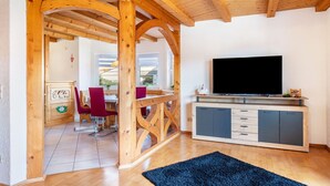 A wooden interior with a TV, a dining area, and a kitchen. - Semi-detached House Christa with Parking, Terrace, Private Garden and Balcony (Schonach im Schwarzwald)