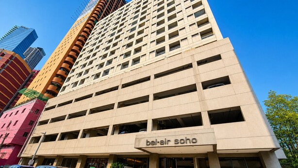 A multi-story building with a sign reading 'bakair soho' at the entrance. - Poblacion Suites by SMS Hospitality (Makati)