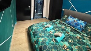 Une chambre à coucher avec un lit, une télévision et une porte donnant sur un balcon.