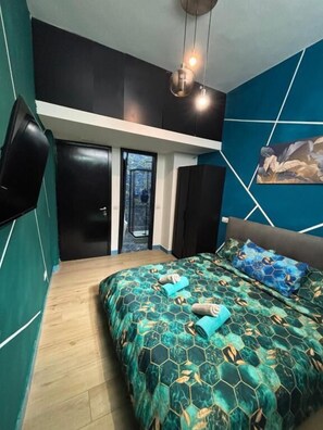 A bedroom with a bed, a TV, and a door leading to a balcony. - Milano underground (Milan)