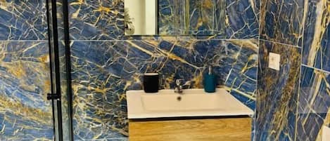 Deluxe tweepersoonskamer | Badkamer | Een douche, een haardroger, handdoeken, zeep